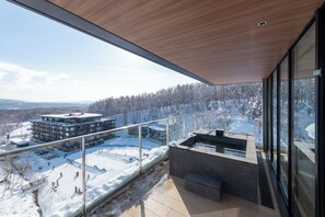 A modern building with a glass balcony overlooking a snowy landscape and a ski slope. - Niseko Kyo (Kutchan)