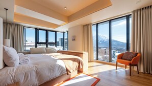Une chambre d’hôtel moderne avec un grand lit, un bureau et une vue sur la montagne.