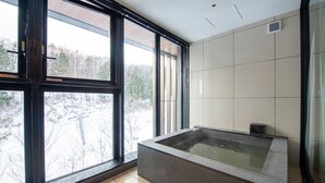Une salle de bain moderne avec une grande fenêtre, une baignoire et des murs carrelés.