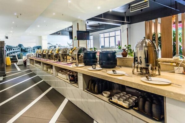 A modern breakfast bar with a variety of coffee and tea options, a flat-screen TV, and a view of a traditional building through the windows. - Dali Wenyue Hotel (Erhai Ecological Corridor Branch) (Dali City)