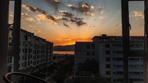 A view of a sunset over a cityscape with buildings and a body of water in the distance. - Dali Wenyue Hotel (Erhai Ecological Corridor Branch) (Dali City)