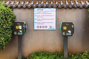 A wall with a sign and two payment machines. - Dali Wenyue Hotel (Erhai Ecological Corridor Branch) (Dali City)