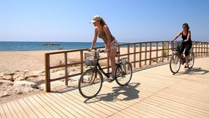 A wooden boardwalk by the beach with two bicycles. - Apartamento Paris (Miami Playa)