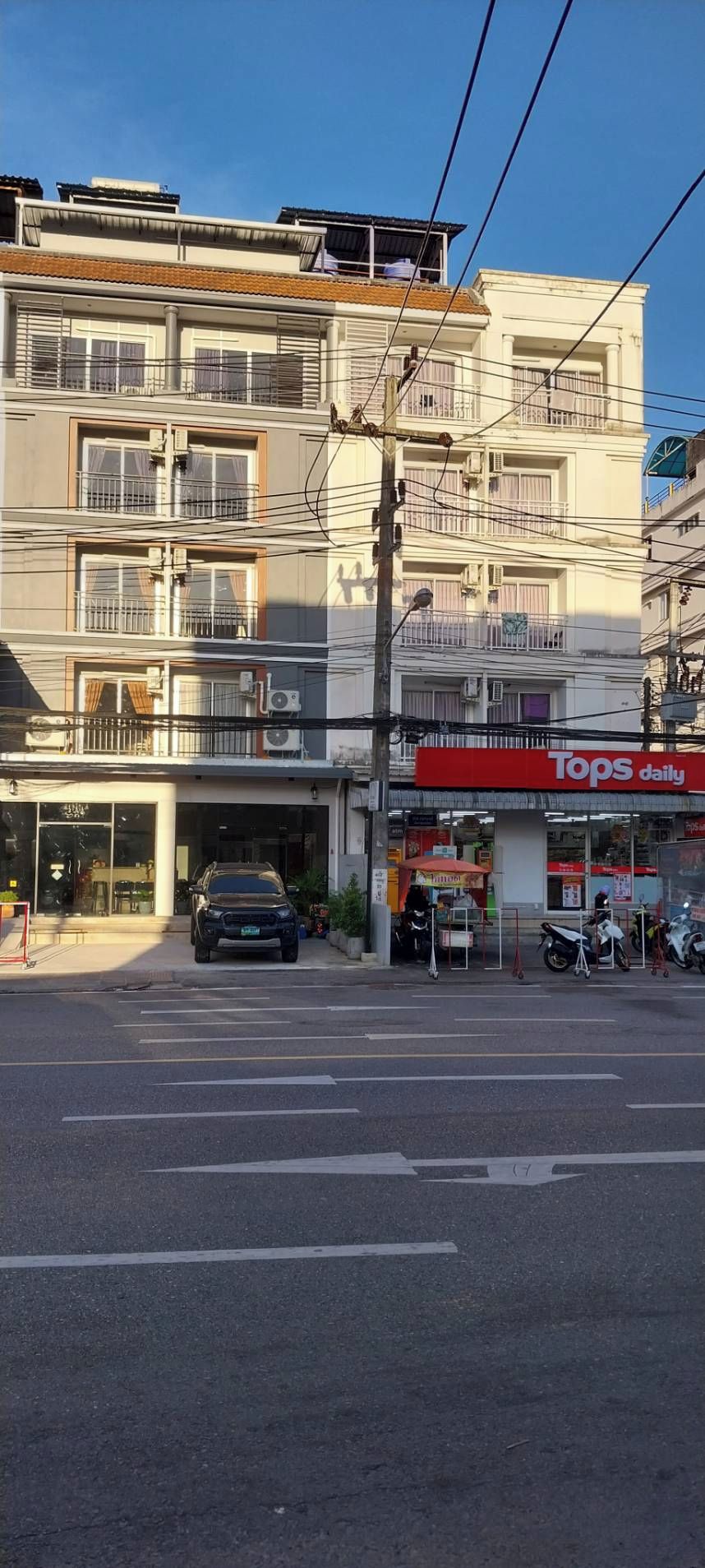 A multi-story building with a storefront labeled 'Tops daily' at street level.