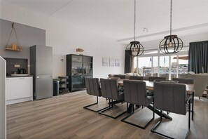 Enjoy meals in the dining area with a wooden table and six chairs, and take in the view from the large window.