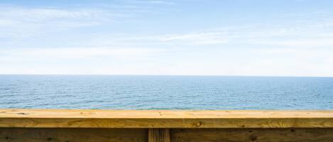 Barandilla de madera con vistas al mar tranquilo.