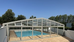 A modern glass-enclosed pool area with a clear view of the pool and surrounding greenery. - Chalet Eguskitsua avec piscine (Hasparren)