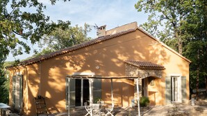 Una casa rústica con un patio, paredes de piedra y techo de tejas.