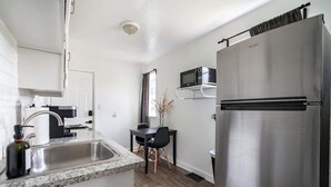 Una cucina moderna con un frigorifero in acciaio inossidabile, un forno a microonde e un lavandino.