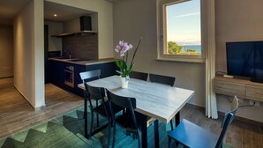 Une cuisine moderne avec un coin repas, une grande fenêtre offrant une belle vue et un téléviseur à écran plat.