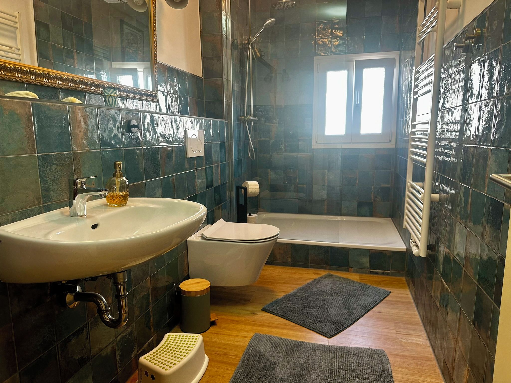 Een badkamer met een wastafel, toilet, douche en bad.