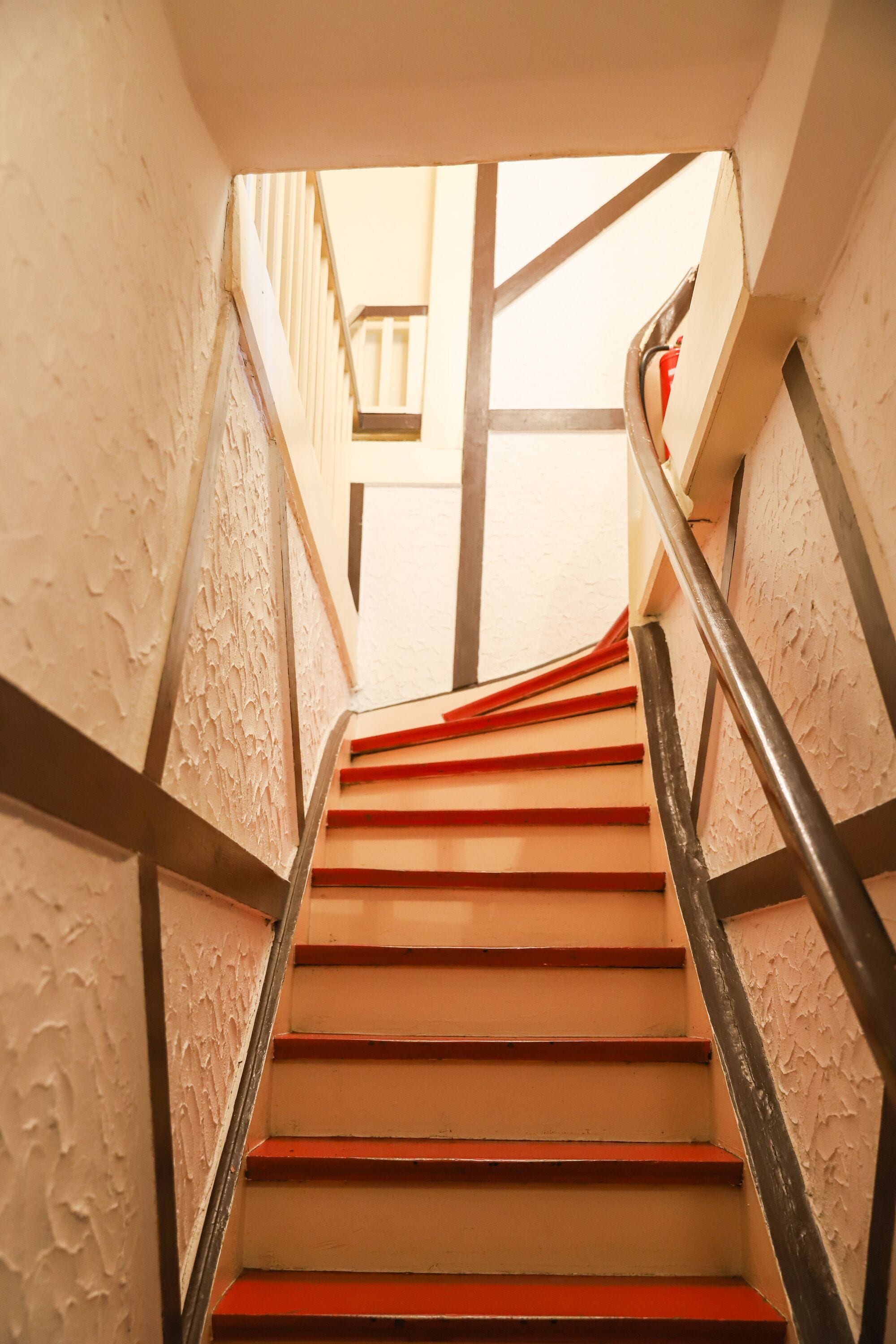 Eine Treppe mit roten Stufen und einem Metallgeländer.