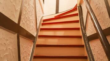 Eine Treppe mit roten Stufen und einem Metallgeländer.