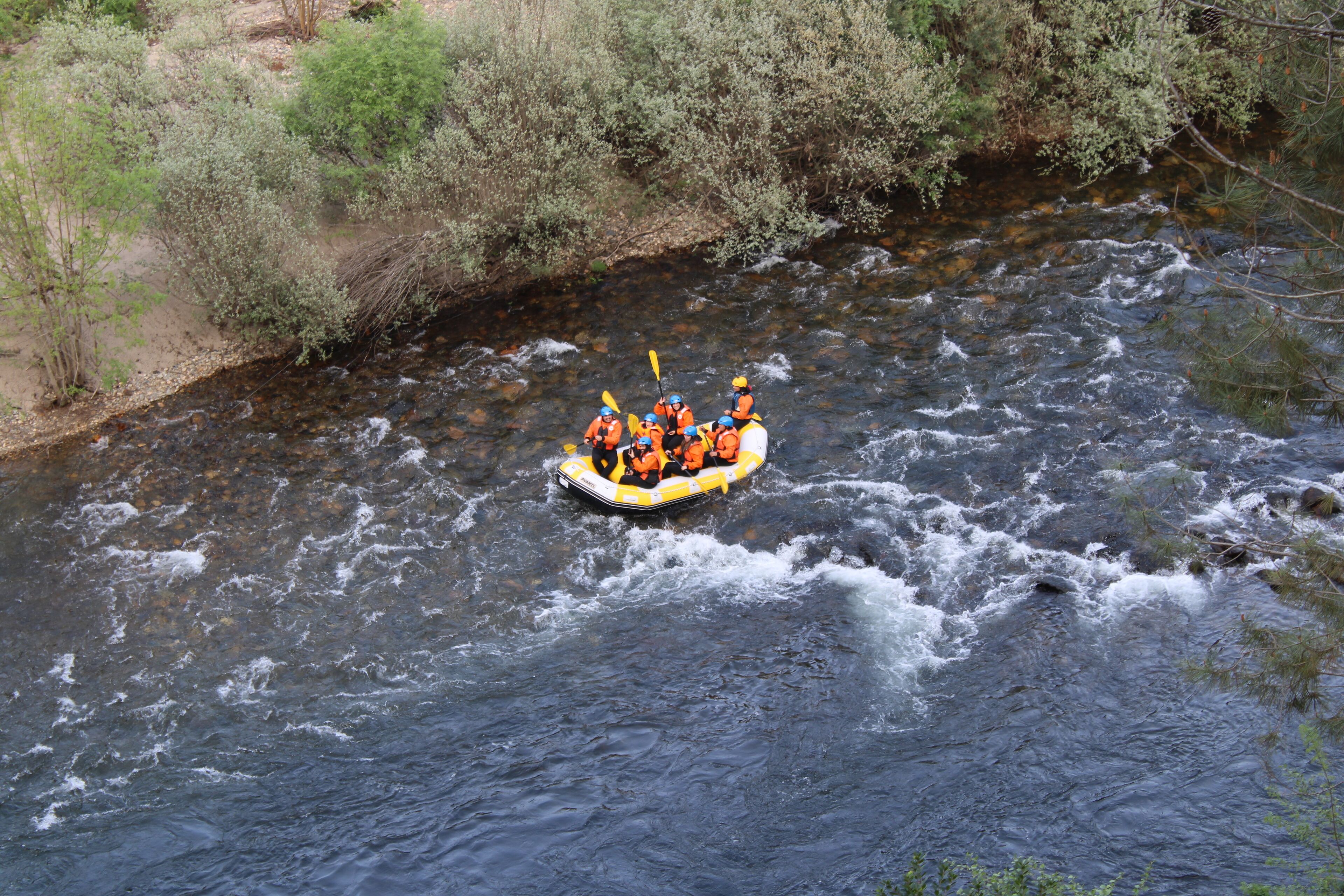 Un groupe de personnes à bord d’un radeau naviguant sur une rivière.