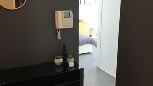 A modern bathroom with a black vanity, two round mirrors, a wall-mounted phone, and a small plant display. - Appartement Avec Terrasse et Parking à Anglet (Anglet)