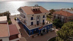 Ein Hotel mit einem Schild mit der Aufschrift 'HOTEL SEAGARDEN', das auf einen Strand blickt.