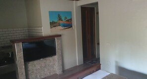 Una cocina con salpicadero de azulejos, estufa integrada y un cuadro con una escena de playa.