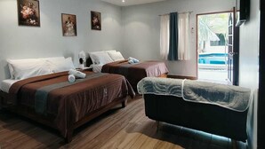 A hotel room with two beds, a sofa, and a TV. - Alona Beach Poolside Hotel (Panglao)