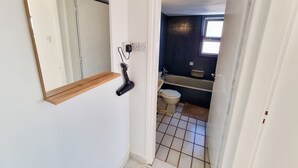 A bathroom with a toilet, sink, and bathtub. - City View Rooms (Larnaca)