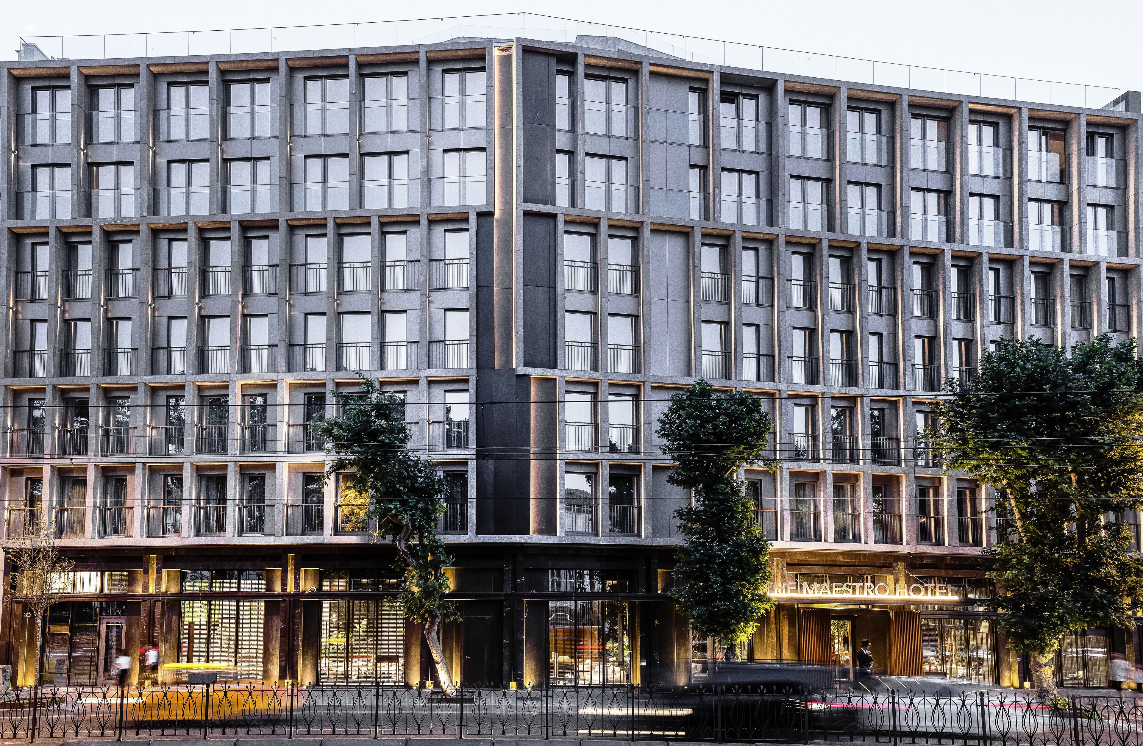 A modern hotel with a symmetrical facade, large windows, and a prominent entrance.