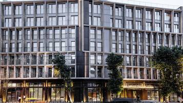 A modern hotel with a symmetrical facade, large windows, and a prominent entrance.
