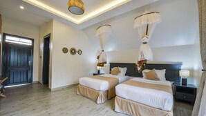A hotel room with two beds, a dark wooden door, a ceiling light, and a nightstand with a lamp. - Kabale Safari Club (Kabale)