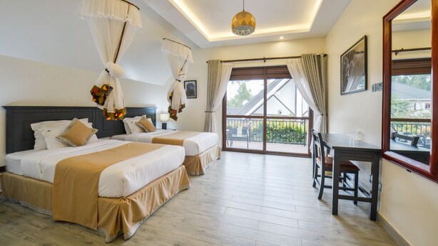 A hotel room with two beds, a balcony, a desk, and a large window. - Kabale Safari Club (Kabale)