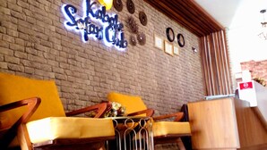 A reception area with a brick wall, wooden reception desk, and a neon sign. - Kabale Safari Club (Kabale)