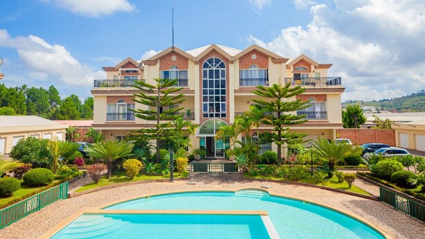 A multi-story hotel with a swimming pool in front. - Appartements - Le Paradisier Ambatobe (Antananarivo)