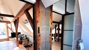 Un loft espacioso con vigas de madera a la vista, un tragaluz grande y un diseño interior moderno.