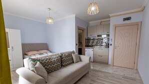 Un apartamento moderno con sala de estar, que incluye un sofá, y una cocina al fondo.
