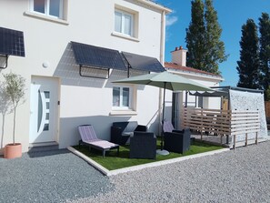 A modern house with a covered patio, solar panels, and a small garden. - R & C - Room and Calm (Challans)
