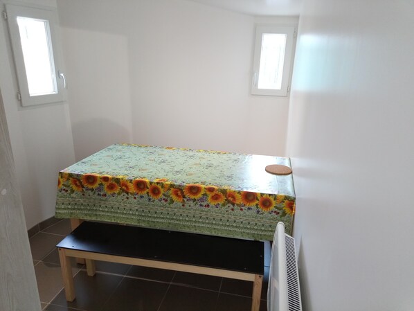 A small room with a bed, a table, and two windows. - R & C - Room and Calm (Challans)