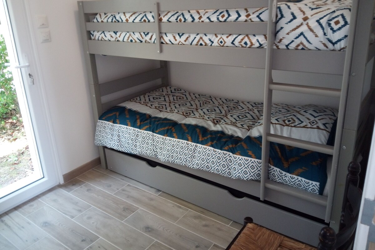 A bunk bed with patterned bedding and a wooden floor.