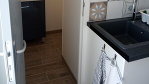 A kitchen with a black countertop, a sink, and a tiled backsplash.
