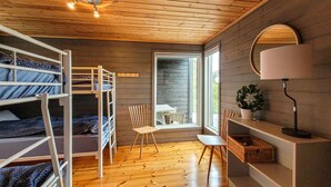 Habitación con literas, un escritorio, una silla y una planta en maceta.