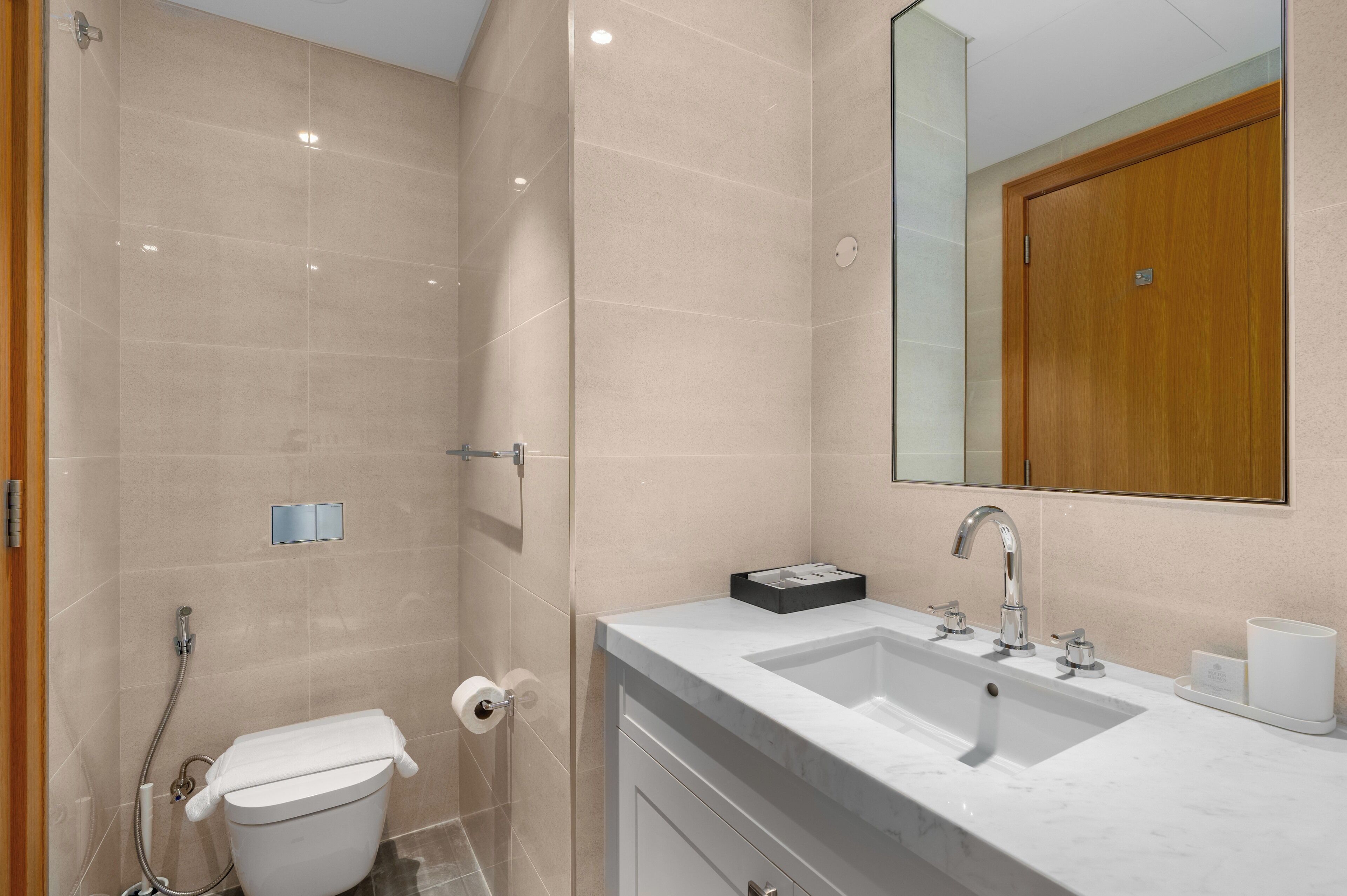 A modern bathroom with a shower, toilet, and sink.