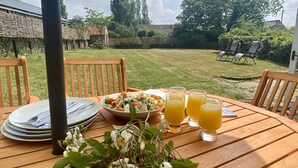 A wooden table set outdoors with plates, cutlery, a bowl of salad, and glasses of orange juice. - Lower Farm Cottage -  Stalbridge Weston, Sherborne (Sturminster Newton, Dorset)