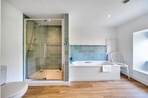 Een bad/douchecombinatie, handdoeken