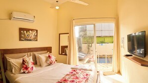 A bedroom with a bed, a TV, a window, and a ladder. - Adrista Divine Cottages (Arambol)