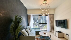 A modern living room with a sofa, coffee table, and TV. - LuxBnB Dubai Opera Act-1 Boulevard Views (Dubai)