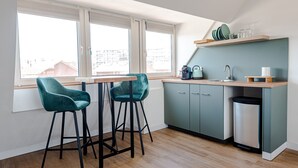 Een moderne keuken met twee barkrukken, een raam en een inbouwspoelbak.