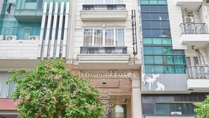 A hotel with a modern facade, multiple balconies, and a visible entrance with steps leading up to the door. - Bin Bin 10 - Mimosa Hotel near Tan Son Nhat Airport (Ho Chi Minh City)