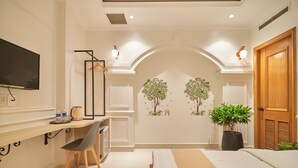 A modern bedroom with a bed, desk, chair, and potted plants. - Bin Bin 10 - Mimosa Hotel near Tan Son Nhat Airport (Ho Chi Minh City)
