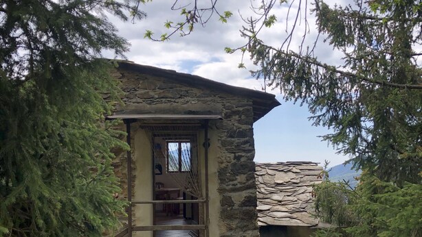 A stone building with a wooden door and a small porch.