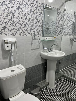 A modern bathroom with a toilet, sink, and shower. - Ayva Hotel (Tashkent)