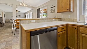 A kitchen with wooden cabinets, a stainless steel dishwasher, and a tiled backsplash. - Large Yard~Great Location~Pet Friendly~Fast Wifi (Boise)