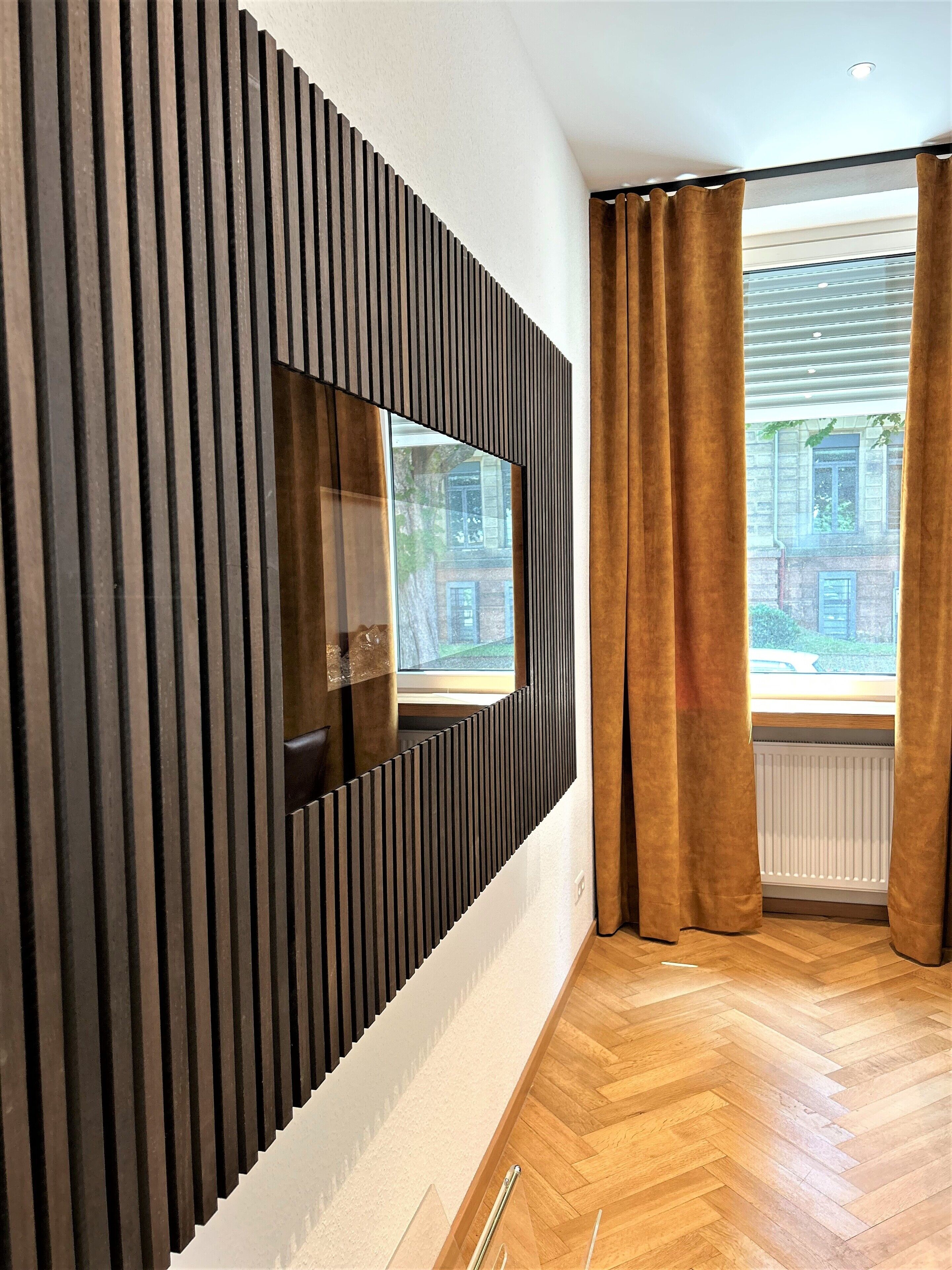Ein modernes Interieur mit Wand-Fernseher, Holzboden und einem fensterbepflegten Fenster.