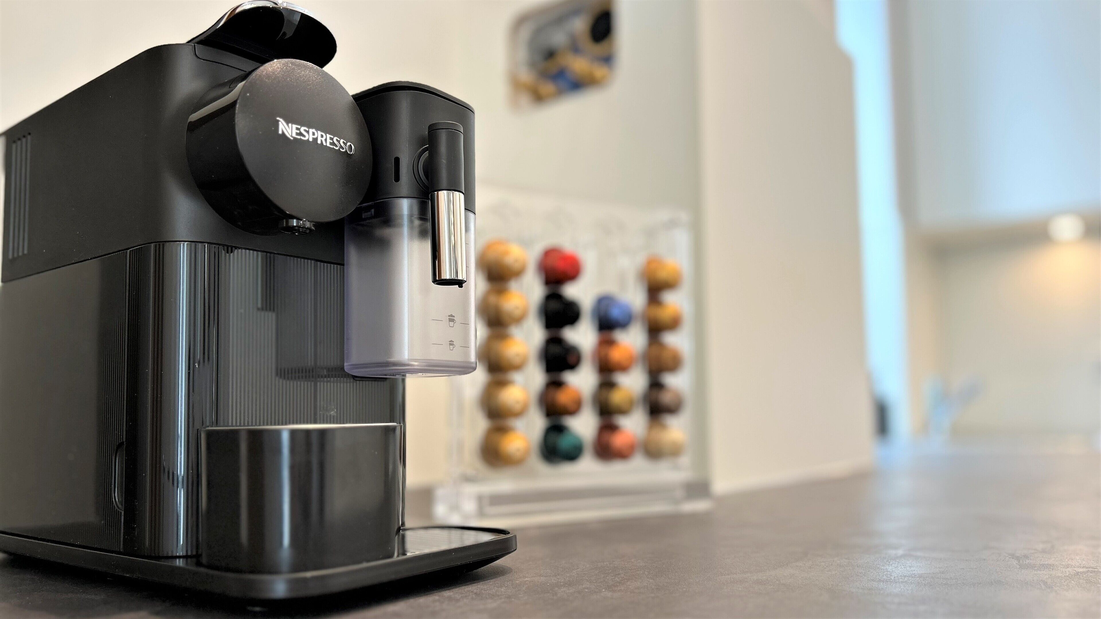Máquina de café Nespresso com reservatório de água e suporte para cápsulas.
