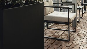 Une terrasse avec des sièges extérieurs, des plantes en pot et une vue sur les bâtiments.